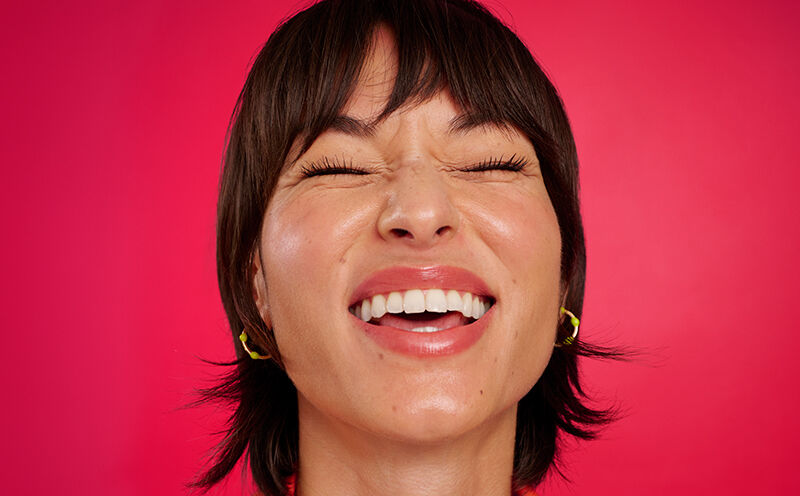 Woman with a big smile on red background