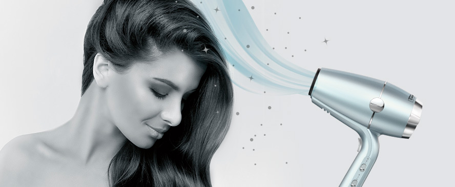 Fotografía de una mujer usando el secador de cabello Smoothwrap™. La terapia iónica doble equilibra la carga iónica del cabello.