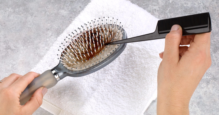 Fotografía que muestra cómo quitar el pelo apelmazado en un cepillo con la punta del mango de un peine de púa